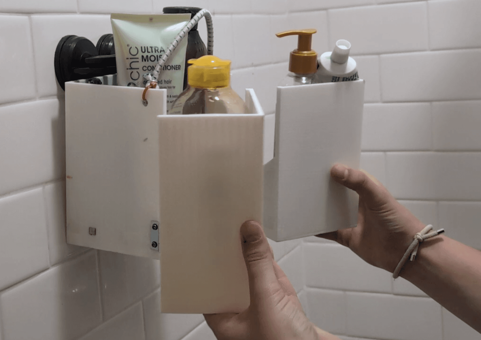 The working prototype suction-mounted in a shower, loaded with products.